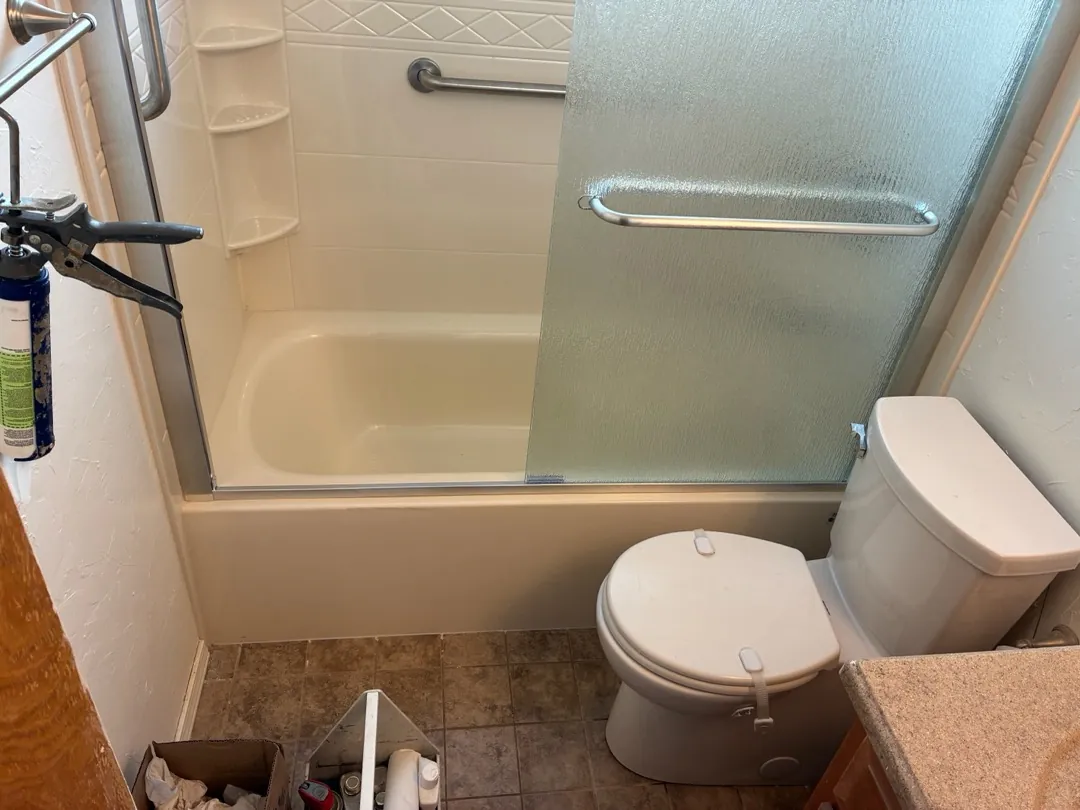 New Edmond bathtub with acrylic walls, corner shelves, grab bars and sliding door