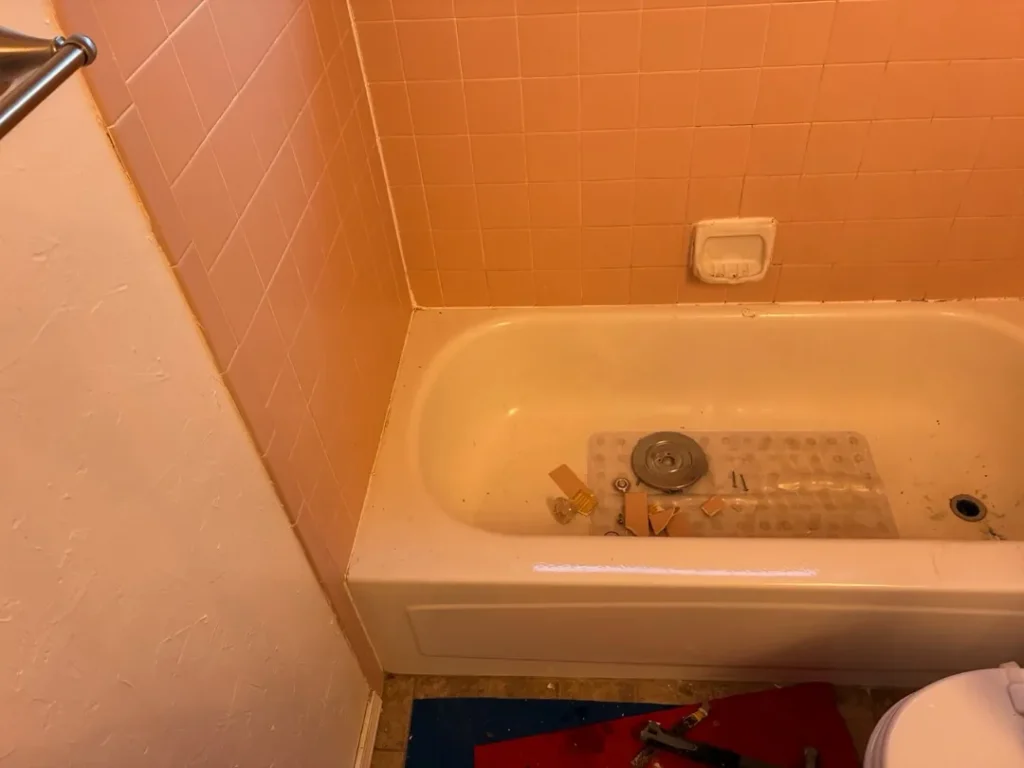 Original Edmond bathtub and square-tile walls before replacement