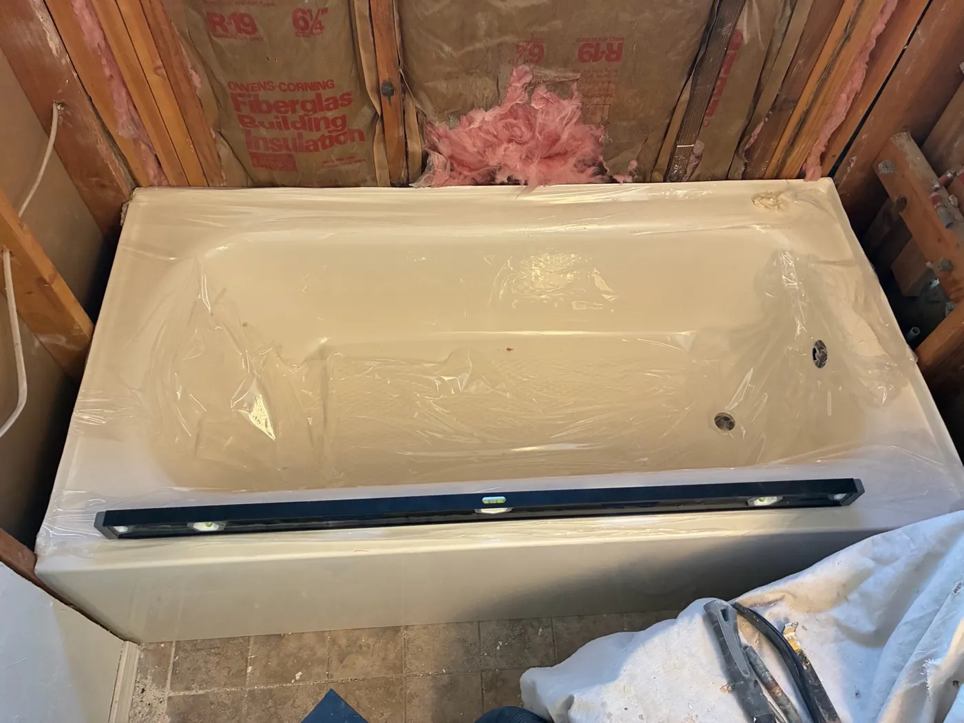 Edmond bath installation showing a new tub and exposed wall framing