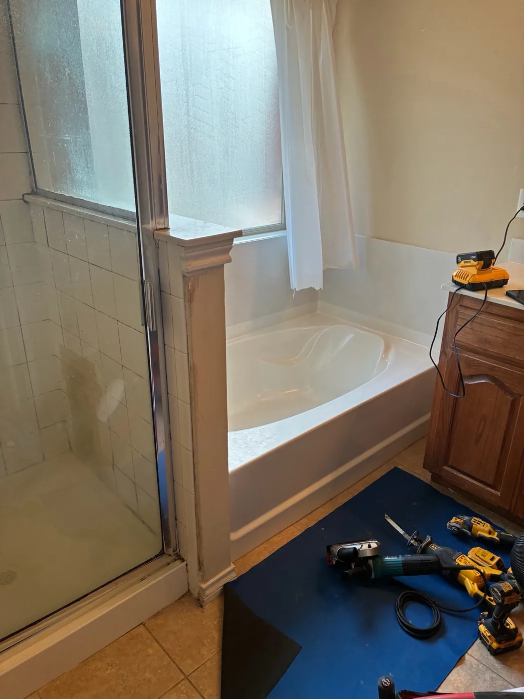 Yukon bathtub beneath a window before replacement with a walk-in shower